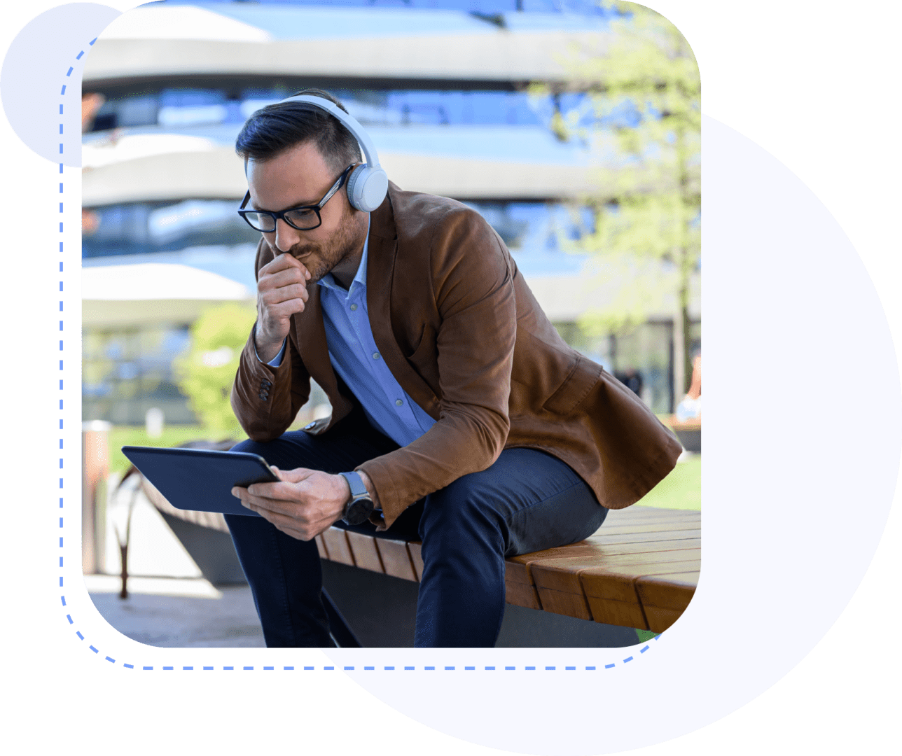 Man with headphones using tablet on bench